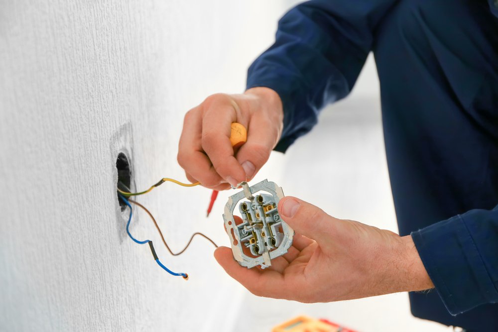 electrician,attaching,wires,to,socket,in,new,building,,closeup